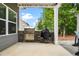 Outdoor kitchen on the patio features a built-in grill, prep space, and stone accents at 132 Berkleigh Trails Dr, Hiram, GA 30141