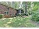 Lush backyard featuring a brick home with a screened porch and mature trees at 1970 Fisher Ne Trl, Atlanta, GA 30345