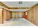 Paneled basement featuring neutral carpet, storage, and a red exit door providing access to the outside at 1970 Fisher Ne Trl, Atlanta, GA 30345