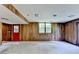 Open basement design featuring paneling, neutral carpet, and a red exit door leading outside at 1970 Fisher Ne Trl, Atlanta, GA 30345