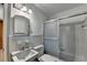 Bathroom with standard tile walls, a white sink, toilet and a glass-enclosed shower and tub combo at 1970 Fisher Ne Trl, Atlanta, GA 30345