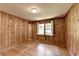 Bedroom featuring knotty pine paneling, hardwood floors, window with curtains and adjacent closet at 1970 Fisher Ne Trl, Atlanta, GA 30345