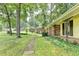 Side view of home features well-maintained lawn, stepping stones, yellow siding, brick accents at 1970 Fisher Ne Trl, Atlanta, GA 30345