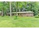 Charming brick home with a lush green lawn and mature trees providing shade and curb appeal at 1970 Fisher Ne Trl, Atlanta, GA 30345
