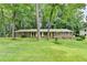 Charming brick home with a lush green lawn and mature trees providing shade and curb appeal at 1970 Fisher Ne Trl, Atlanta, GA 30345