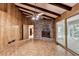 Bright living room with wood paneling, exposed beams, brick fireplace, and sliding glass doors to sunroom at 1970 Fisher Ne Trl, Atlanta, GA 30345
