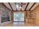 Cozy living room with brick fireplace, beamed ceiling, and natural light from the sliding glass door at 1970 Fisher Ne Trl, Atlanta, GA 30345
