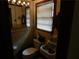 Small bathroom with yellow tile, sink, toilet, mirror with lighting fixture above, and window with blinds at 2765 Rollingwood Se Ln, Atlanta, GA 30316