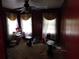 Bedroom with wood walls, dark ceiling fan, curtains, window blinds, and doorway to the side at 2765 Rollingwood Se Ln, Atlanta, GA 30316