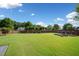 Expansive backyard featuring a well-maintained lawn, garden beds, and mature trees at 3850 Calomel Dr, Cumming, GA 30040