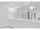 Bright bathroom featuring double sinks, white cabinets, a large mirror, and modern lighting at 3850 Calomel Dr, Cumming, GA 30040
