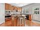 Well-lit kitchen with wood cabinets, stainless appliances, granite countertops and hardwood floors at 3850 Calomel Dr, Cumming, GA 30040
