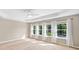 Bright main bedroom featuring a tray ceiling, ceiling fan, and large windows with white curtains at 3850 Calomel Dr, Cumming, GA 30040