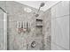 Spa-like shower with elegant gray tiling, a rainfall showerhead, and recessed shelving at 3850 Calomel Dr, Cumming, GA 30040