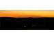 Landscape view showing sunset over trees and buildings, with sky in shades of orange and black at 4160 Grandview Vista St, Cumming, GA 30028