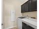 Laundry area has a washing machine, dryer, and overhead cabinets at 4160 Grandview Vista St, Cumming, GA 30028