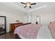 Main bedroom featuring hardwood floors, tray ceiling, and a dresser with floral arrangements at 4160 Grandview Vista St, Cumming, GA 30028