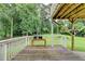 Wooden deck with a railing overlooking the expansive backyard and mature trees at 4444 Lisa Nw Way, Lilburn, GA 30047