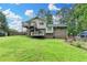 Spacious backyard with a multi-level deck, green lawn, and a wooded backdrop at 4444 Lisa Nw Way, Lilburn, GA 30047