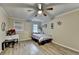 Charming bedroom featuring wood floors, a ceiling fan, and a door to the backyard at 4444 Lisa Nw Way, Lilburn, GA 30047