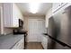 Galley kitchen with white cabinetry, stainless steel appliances, and pantry closet at 591 Emory Oaks Way # 591, Decatur, GA 30033