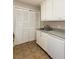 This kitchen features white cabinets and a stainless steel sink and a closet with shutter doors at 591 Emory Oaks Way # 591, Decatur, GA 30033