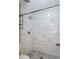 Elegant shower featuring marble-look tile walls and a contrasting mosaic tile floor at 591 Emory Oaks Way # 591, Decatur, GA 30033