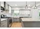 Charming kitchen with stainless appliances, white farmhouse sink, and gray cabinets beneath the white countertop at 2676 Cottonwood Dr, Marietta, GA 30066