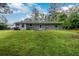 View of the rear of the home and treed back yard with a sloping grade at 3645 Shrewsbury Ct, Snellville, GA 30039