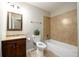 Bright bathroom featuring a tub with tile surround, vanity with wood cabinets, and neutral color palette at 3645 Shrewsbury Ct, Snellville, GA 30039
