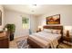Well-lit bedroom with a wooden bed frame, decorative rug, and a large window at 3645 Shrewsbury Ct, Snellville, GA 30039