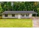 A quaint, single-story home with stone foundation, attached carport, and lush green lawn at 3645 Shrewsbury Ct, Snellville, GA 30039