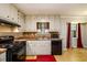 Bright kitchen features white cabinetry and black appliances at 3645 Shrewsbury Ct, Snellville, GA 30039
