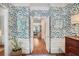 Inviting foyer with leaf-patterned wallpaper, hardwood floors, and white trim, creating a stylish entrance at 377 Camden Ne Rd, Atlanta, GA 30309
