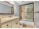 Well-lit bathroom features a vanity with a stone countertop and tiled tub-shower combo at 1155 Admiral Xing, Alpharetta, GA 30005