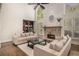 Bright living room featuring a stone fireplace, ceiling fan and built-in bookcase at 1155 Admiral Xing, Alpharetta, GA 30005