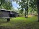 Expansive backyard with a brick house featuring a screened-in porch overlooking the green lawn at 4325 Dawning Ln, Douglasville, GA 30135