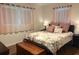 Cozy bedroom with wood floor, two windows, a chest, and a comfy floral bed with pink pillows at 4325 Dawning Ln, Douglasville, GA 30135
