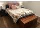 Cozy bedroom with wood floor, two lamps, a chest, and a comfy floral bed with pink pillows at 4325 Dawning Ln, Douglasville, GA 30135