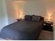 This bedroom has dark gray linens and carpet, modern bedside tables, and lots of natural light at 4325 Dawning Ln, Douglasville, GA 30135