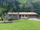 Charming single story home featuring a front lawn, mature trees, and attached garage at 4325 Dawning Ln, Douglasville, GA 30135