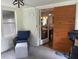 A sunroom featuring white brick walls, carpeted floors, and a wooden sliding door to the dining room at 4325 Dawning Ln, Douglasville, GA 30135