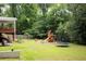 Expansive backyard showcasing a playset, trampoline, garden, and generous green space at 5070 Hensley Dr, Atlanta, GA 30338