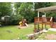 Spacious backyard featuring a wooden deck, playset, and landscaped garden beds at 5070 Hensley Dr, Atlanta, GA 30338
