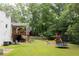 Wide shot of the backyard showing the wooden deck, play area with slide, and manicured lawn at 5070 Hensley Dr, Atlanta, GA 30338