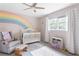 Cozy Bedroom features a white crib, colorful rainbow mural and a ceiling fan at 5070 Hensley Dr, Atlanta, GA 30338