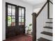 Welcoming entryway boasts hardwood floors, stylish rug, glass front door, and staircase at 5070 Hensley Dr, Atlanta, GA 30338