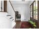 Bright entryway with hardwood floors, staircase, rug, and wooden front door leading to the dining room at 5070 Hensley Dr, Atlanta, GA 30338