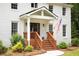 Detailed shot of a front porch with wooden steps, American flag, and accent lanterns at 5070 Hensley Dr, Atlanta, GA 30338