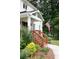 Charming front porch with an American flag, beautiful landscaping, and a welcoming entrance to the home at 5070 Hensley Dr, Atlanta, GA 30338